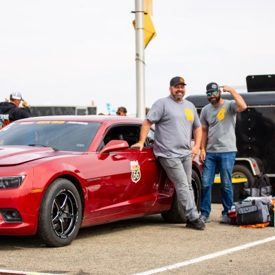 Joseph Potak’s LinkedIn profile photo, pictured beside a red Camaro at a racing event